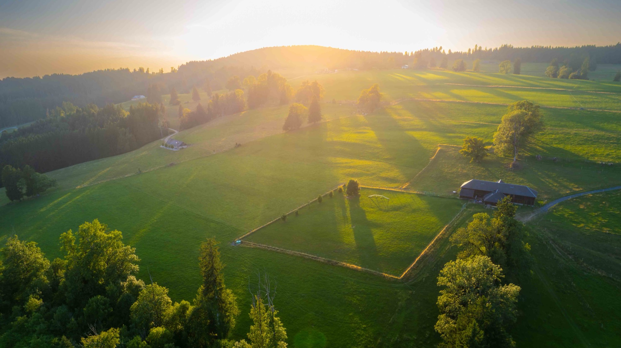 Vue aérienne du terrain d’entraînement de Bulle&Dogs au coucher du soleil